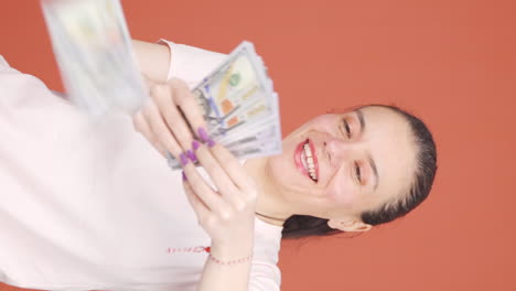 Vertical-video-of-Woman-distributing-banknotes-and-tossing-them-into-the-air.